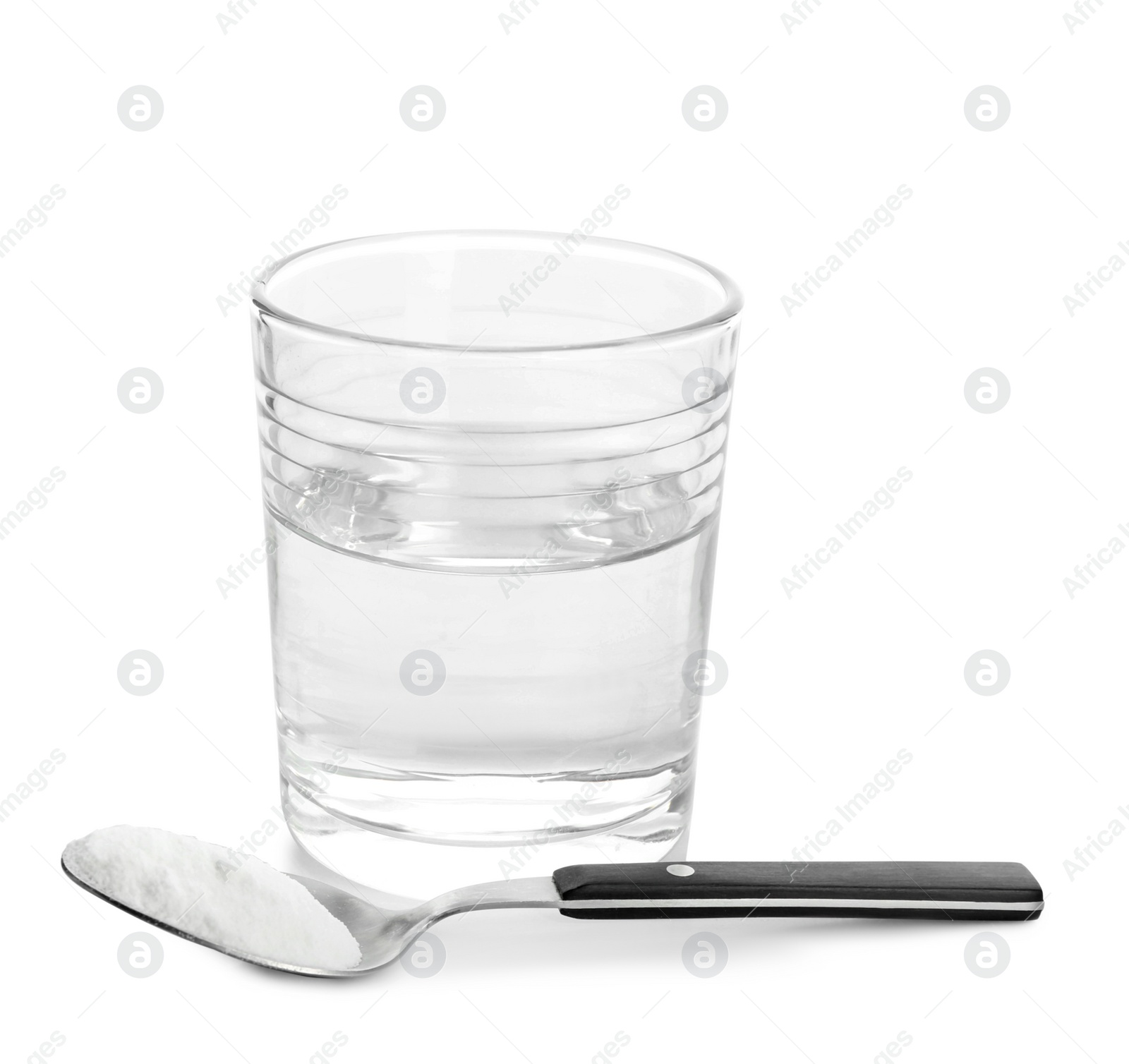 Photo of Glass of water and spoon with baking soda on white background