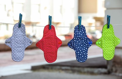 Photo of Many different menstrual cloth pads hanging on rope outdoors