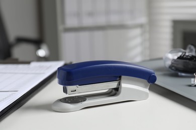 Photo of Stapler on white table indoors, closeup view