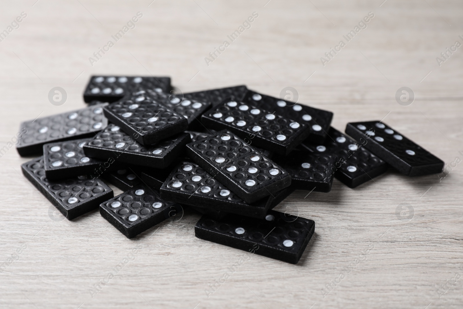 Photo of Pile of black domino tiles on wooden table