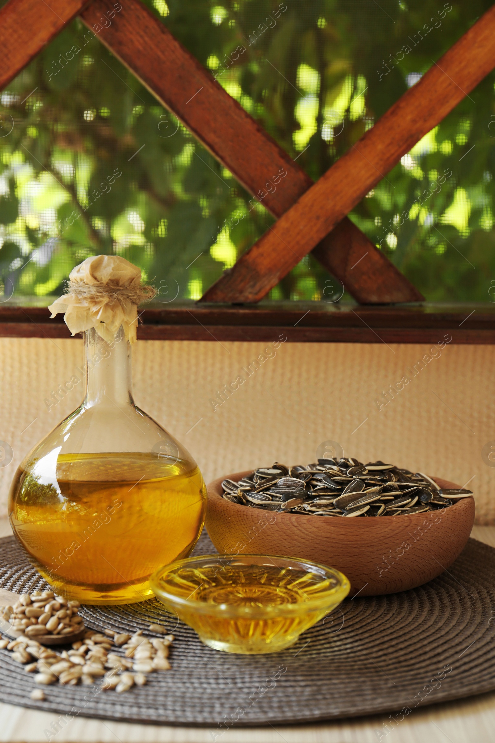 Photo of Organic sunflower oil and seeds on white table