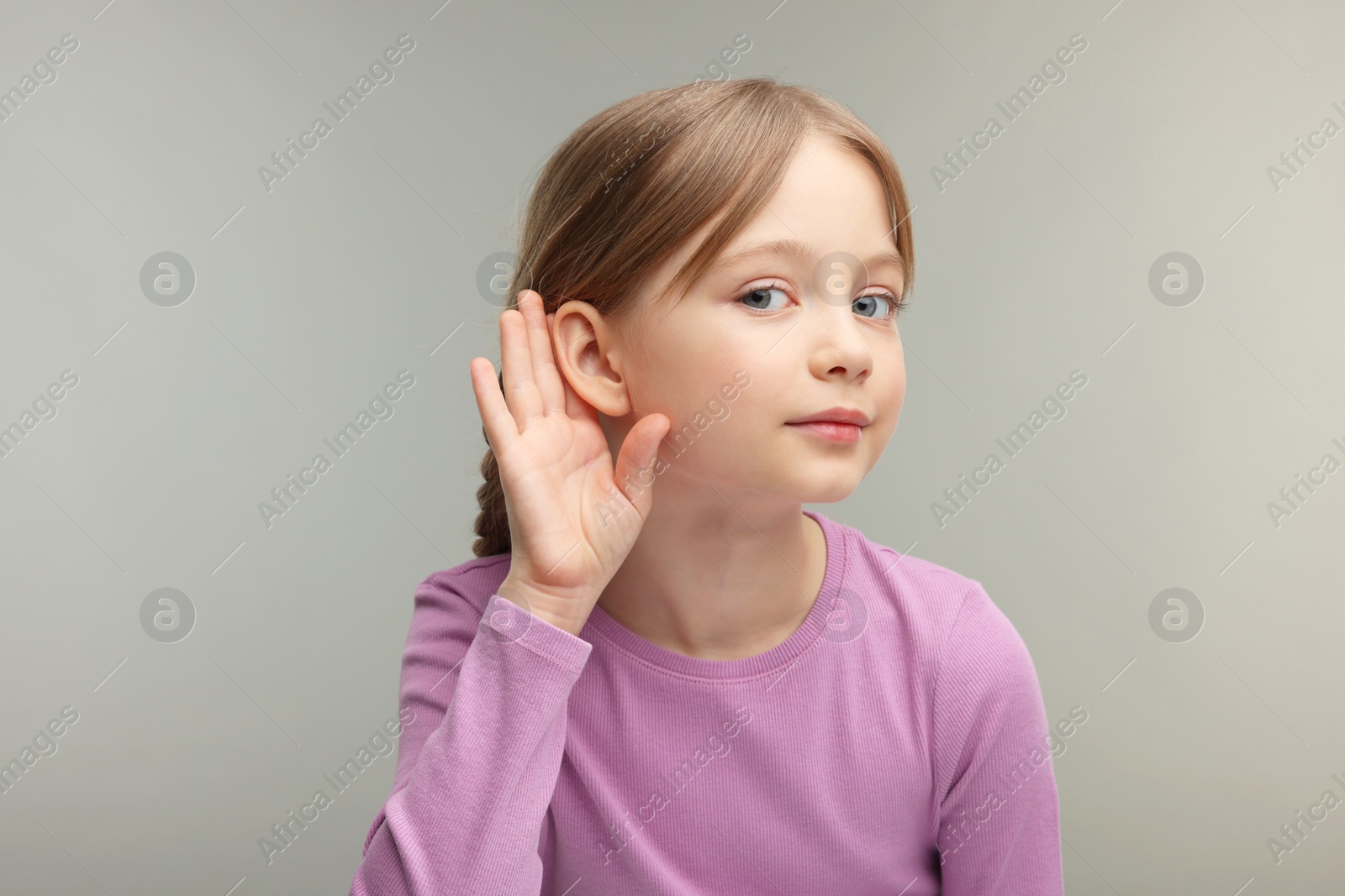 Photo of Little girl with hearing problem on grey background