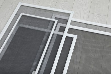 Photo of Set of window screens on wooden floor, above view