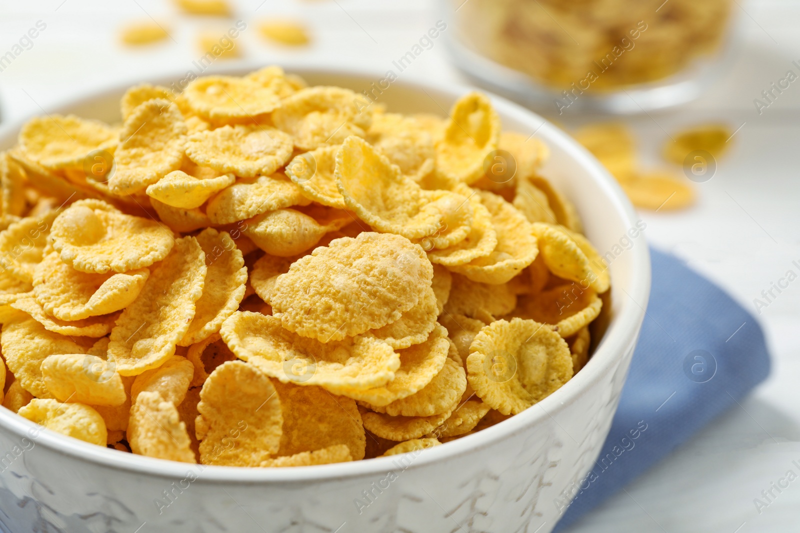 Photo of Tasty corn flakes on white table, closeup