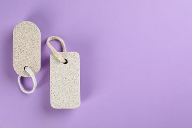 Photo of Pumice stones on violet background, flat lay. Space for text