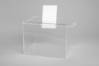 Ballot box with vote on light grey background. Election time