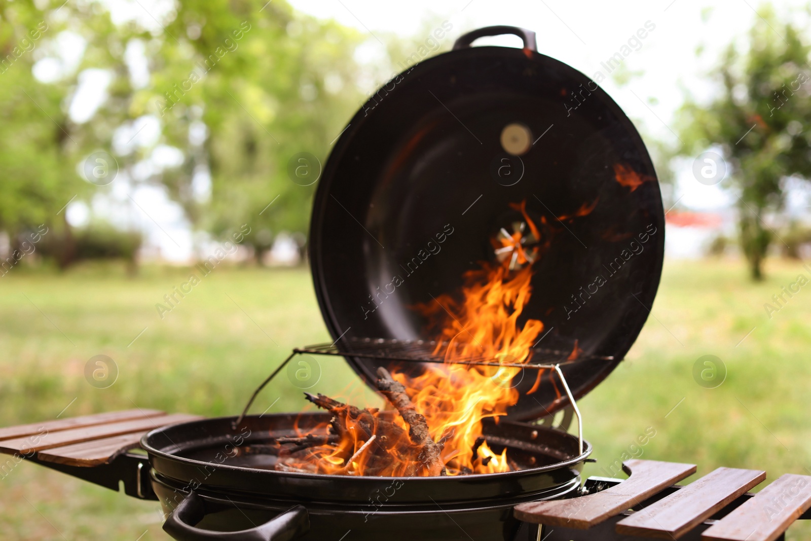 Photo of Modern barbecue grill with fire flames outdoors