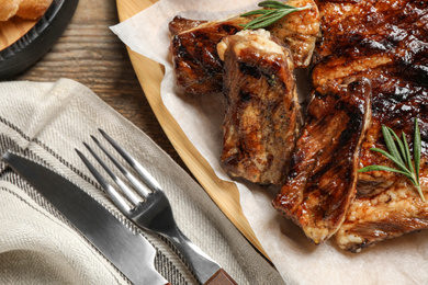 Delicious grilled ribs served on wooden table, closeup