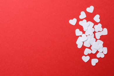 Photo of White paper hearts on red background, flat lay. Space for text