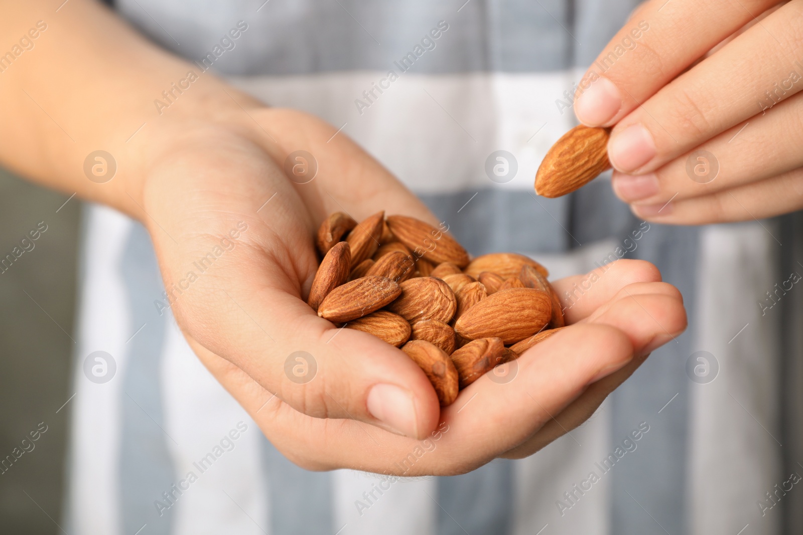 Photo of Woman holding organic almond nuts in hands, closeup