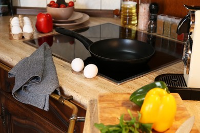 Photo of Fresh eggs and bell pepper on wooden countertop in kitchen. Ingredients for breakfast