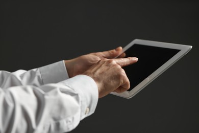 Closeup view of man using new tablet on black background