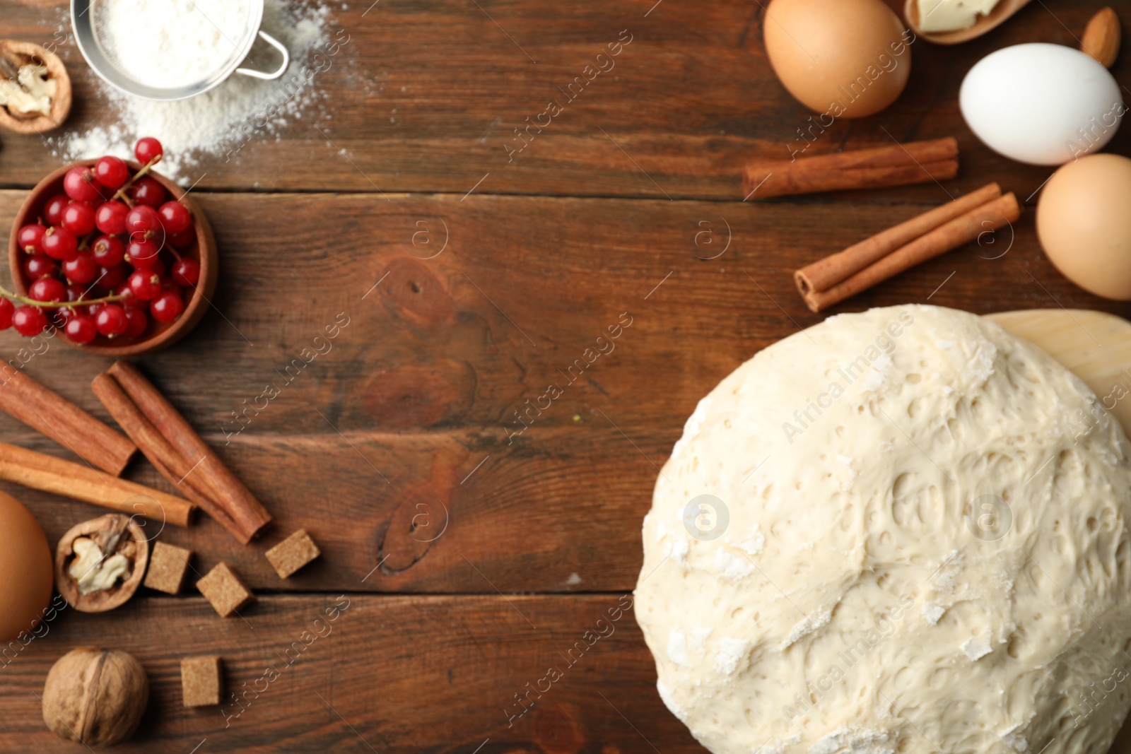 Photo of Flat lay composition with dough on wooden table, space for text. Cooking pastries