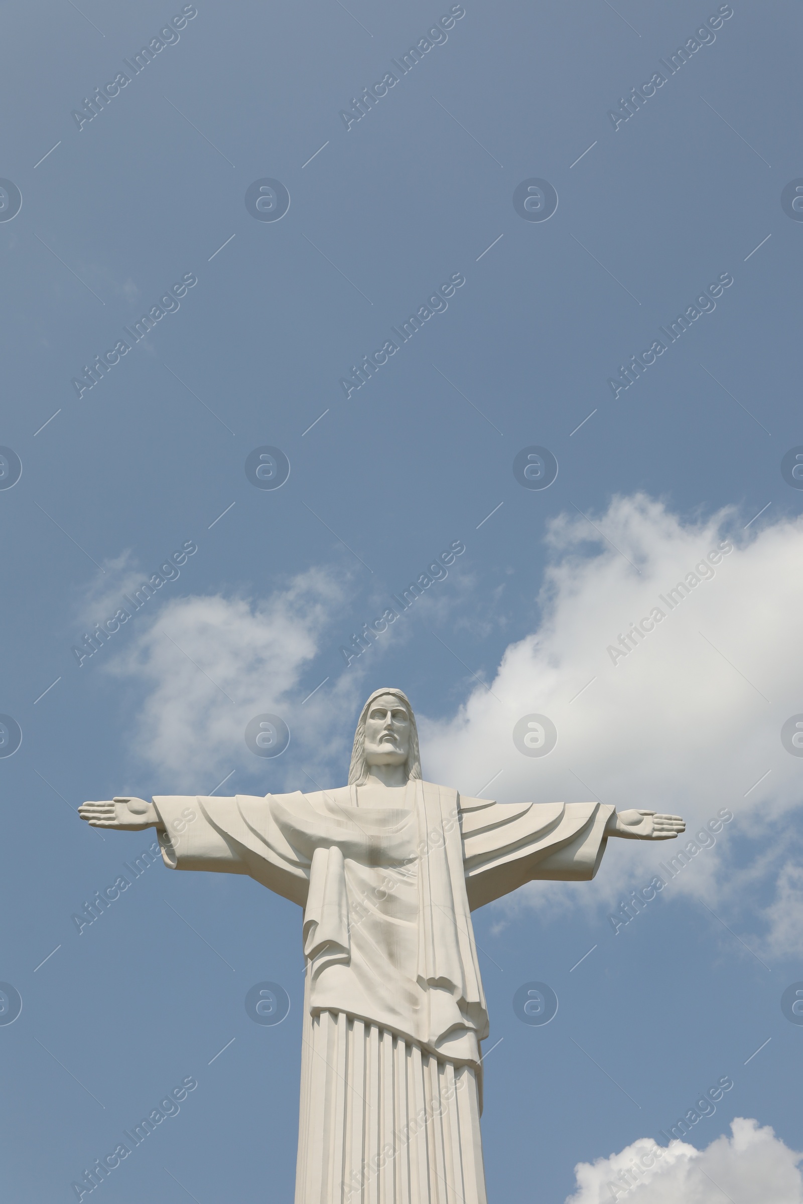 Photo of Truskavets, Ukraine - July 14, 2023: Beautiful statue of Jesus Christ against blue sky, low angle view. Space for text