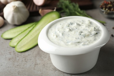 Photo of Cucumber sauce in ceramic bowl on table. Traditional Tzatziki