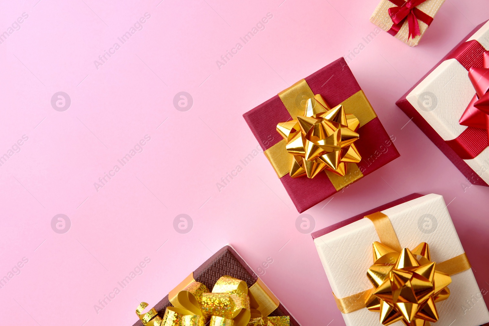 Photo of Flat lay composition with beautiful gift boxes on pink background. Space for text