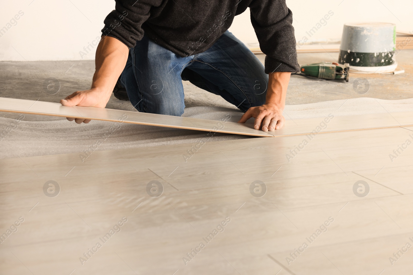 Photo of Professional worker installing new laminate flooring indoors