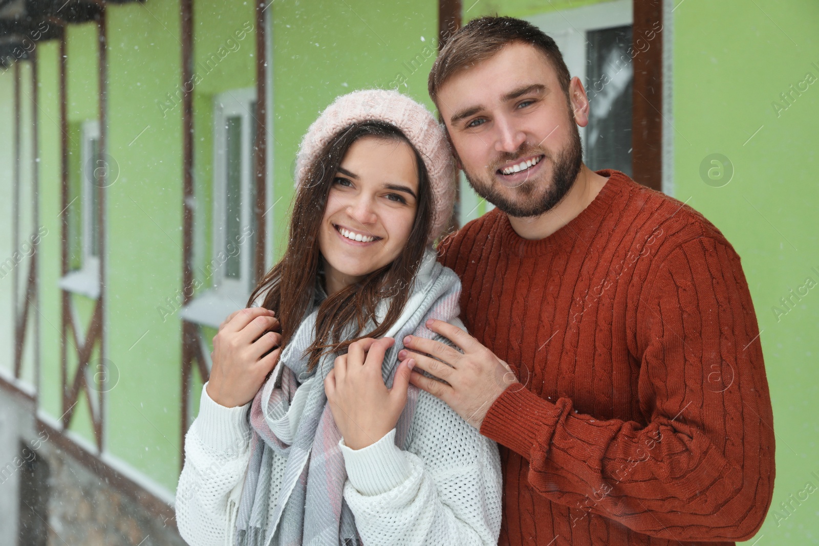 Photo of Lovely couple wearing warm sweaters outdoors on snowy day. Winter season