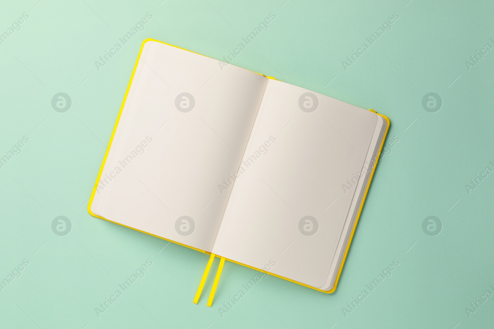 Photo of Blank notebook on turquoise background, top view