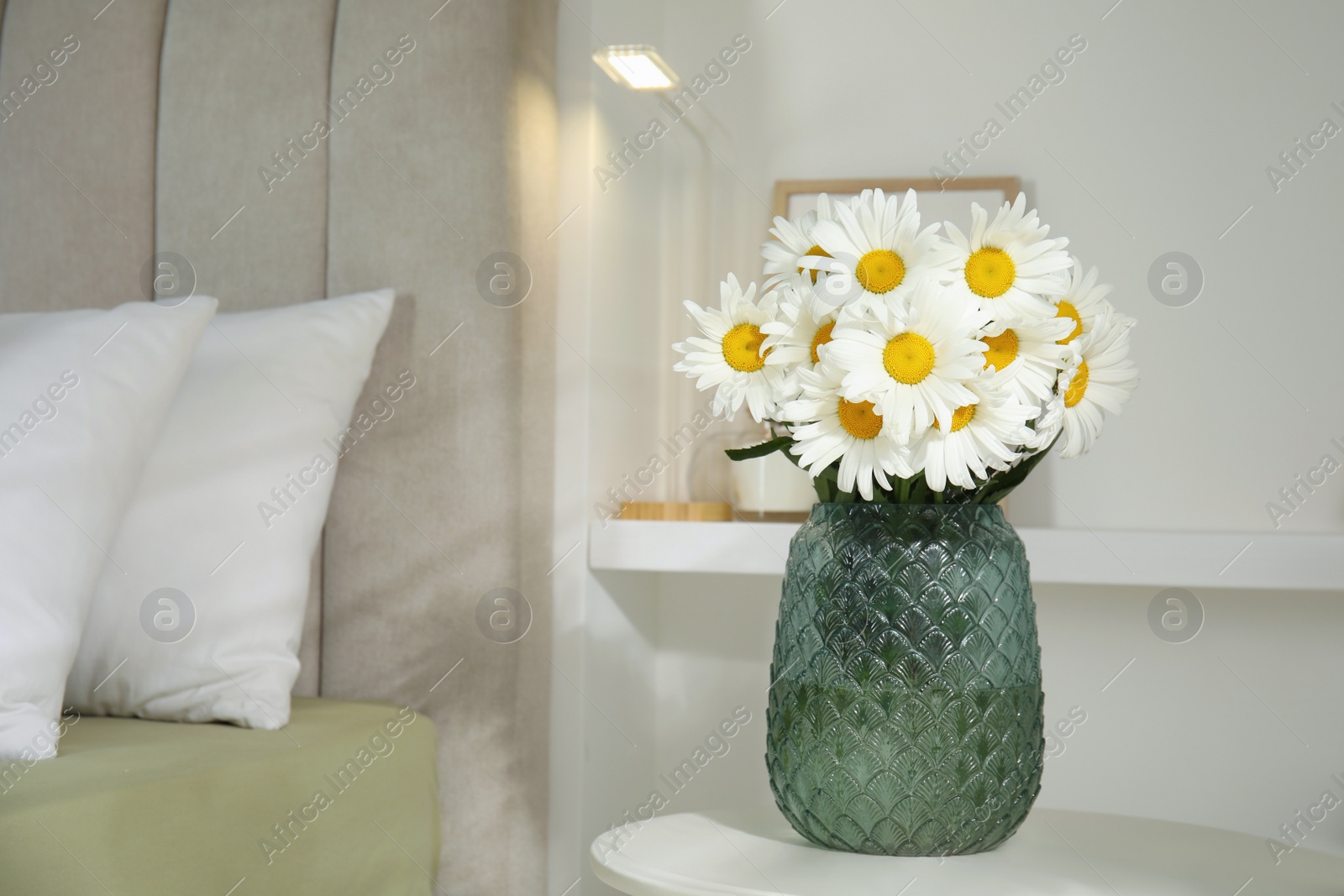 Photo of Bouquet of beautiful daisy flowers on table in bedroom, space for text