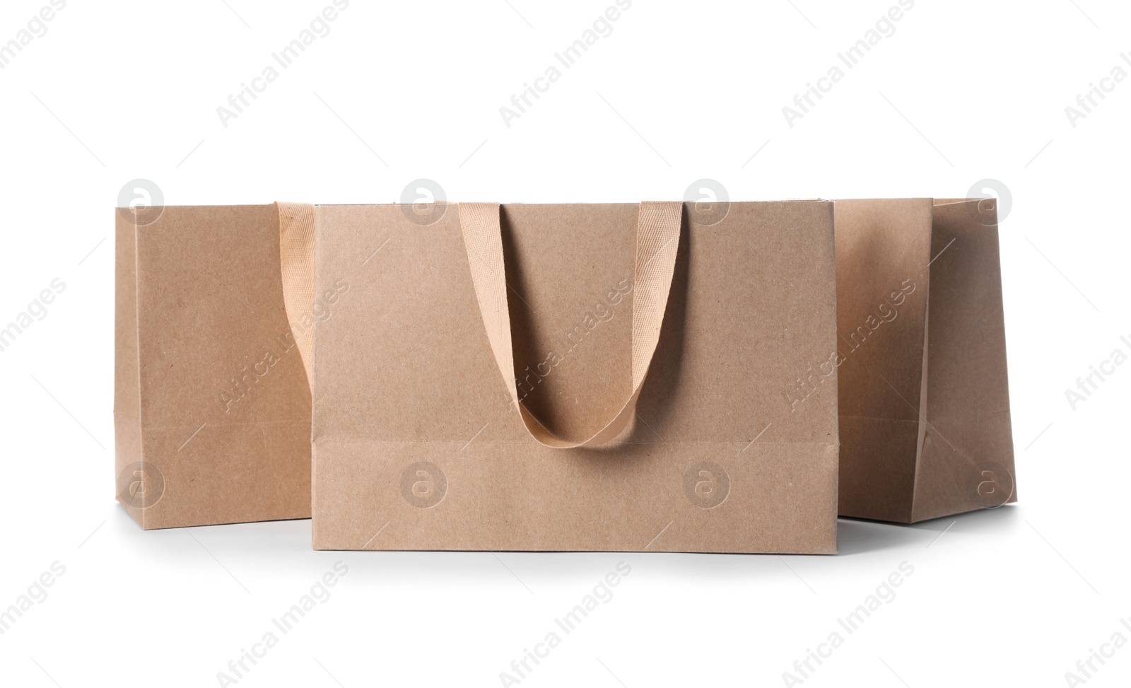 Photo of Paper shopping bags with comfortable handles on white background. Mockup for design