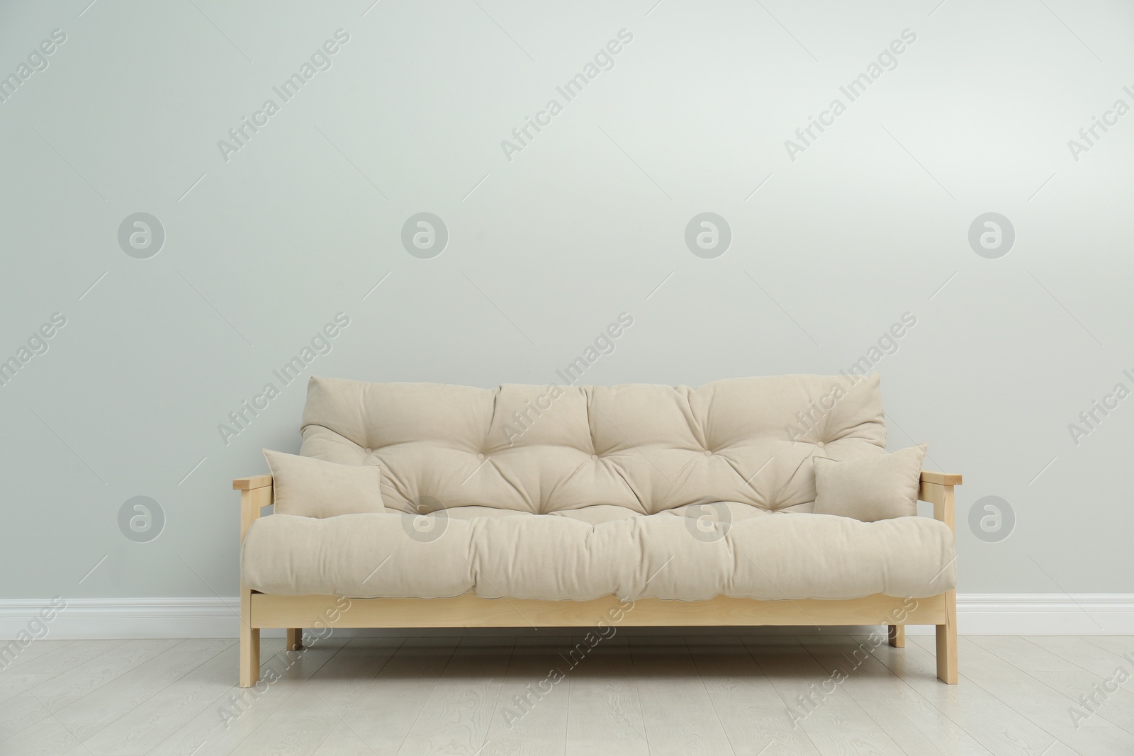 Photo of Stylish beige sofa near light wall indoors