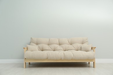 Photo of Stylish beige sofa near light wall indoors