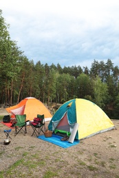 Photo of Camping tents and accessories in wilderness on summer day