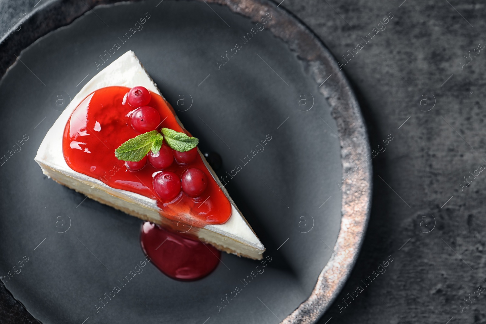 Photo of Delicious cheesecake served with sweet jam on plate, top view