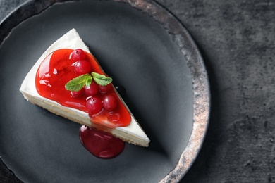 Photo of Delicious cheesecake served with sweet jam on plate, top view