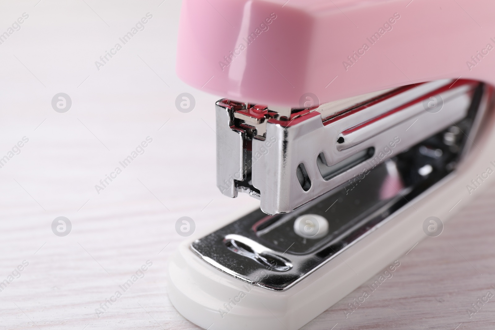 Photo of Stapler on light wooden table, closeup. Space for text