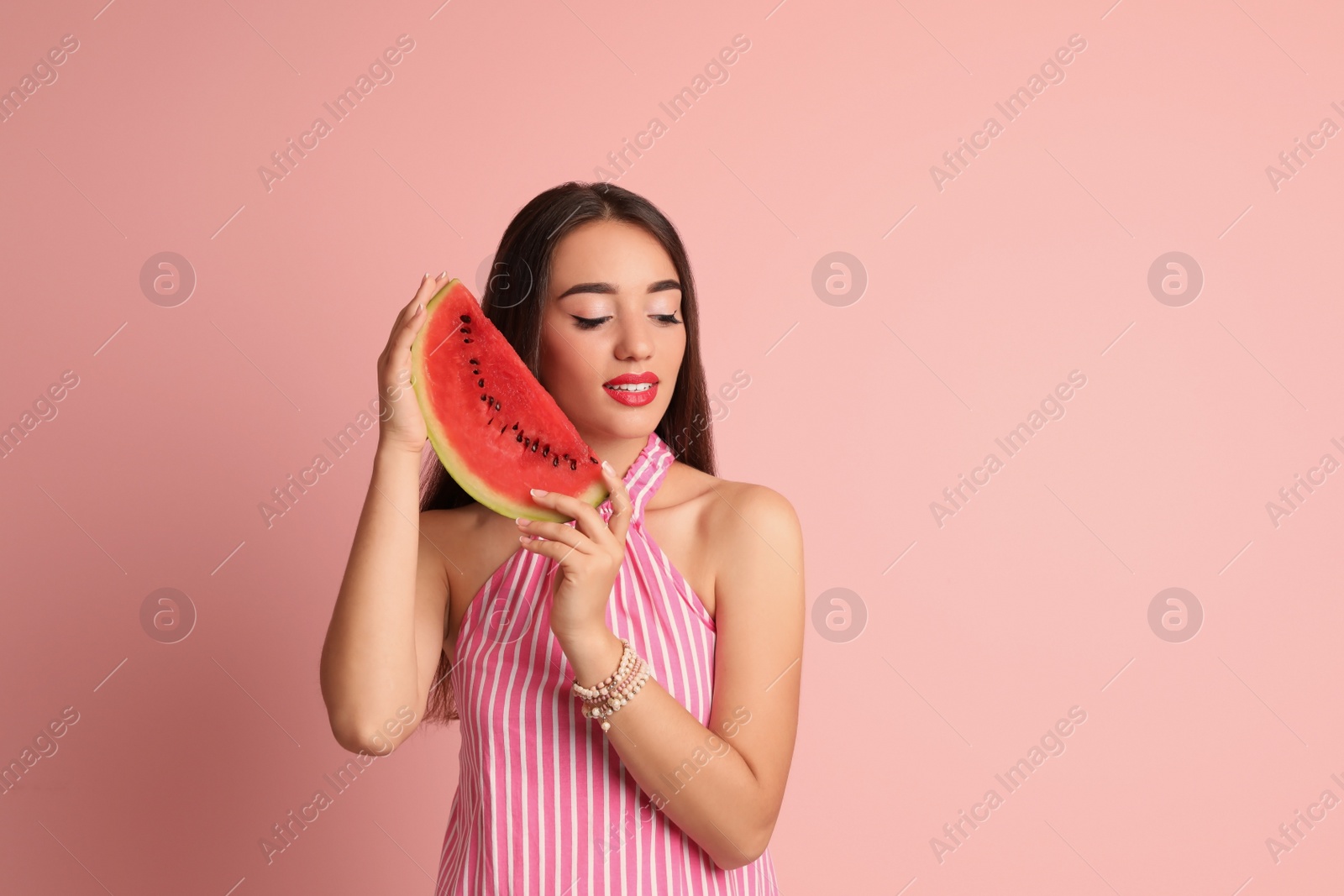 Photo of Beautiful young woman posing with watermelon on color background