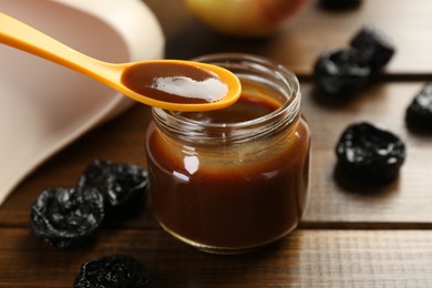 Photo of Eating baby food with spoon at wooden table, closeup