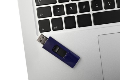 Photo of Usb flash drive onto laptop on white background, top view
