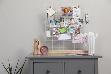 Photo of Chest of drawers with vision board and decor elements near grey wall indoors