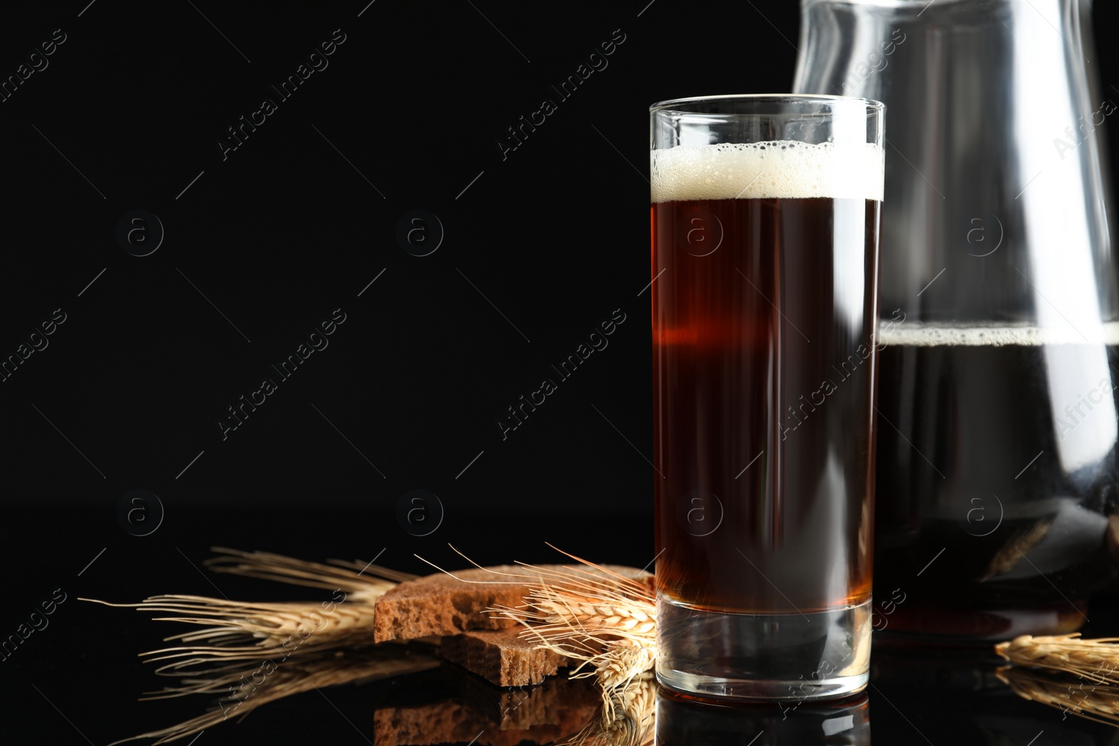 Photo of Delicious kvass, bread and spikes on black background. Space for text