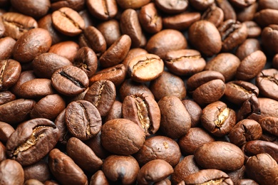 Pile of roasted coffee beans as background, closeup