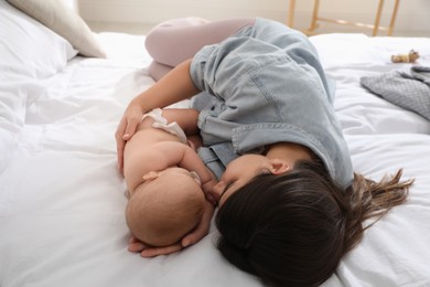 Photo of Mother with her cute baby sleeping on bed at home