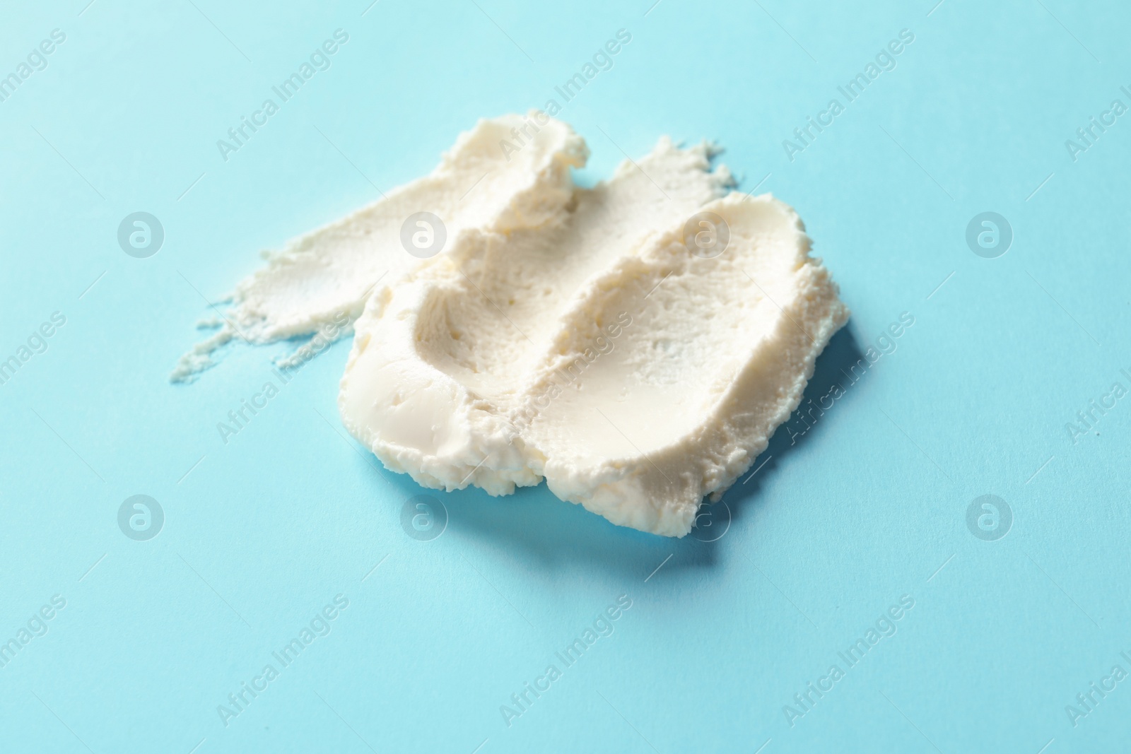 Photo of Smear of tasty cream cheese on color background