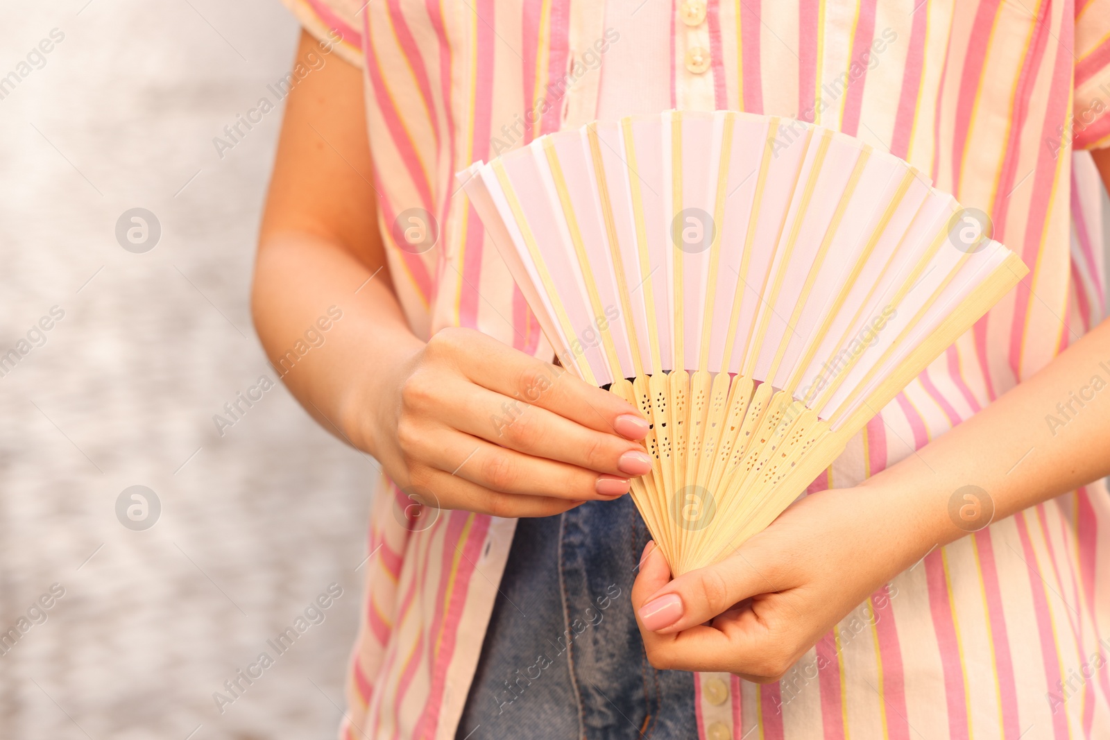 Photo of Woman with white hand fan outdoors, closeup