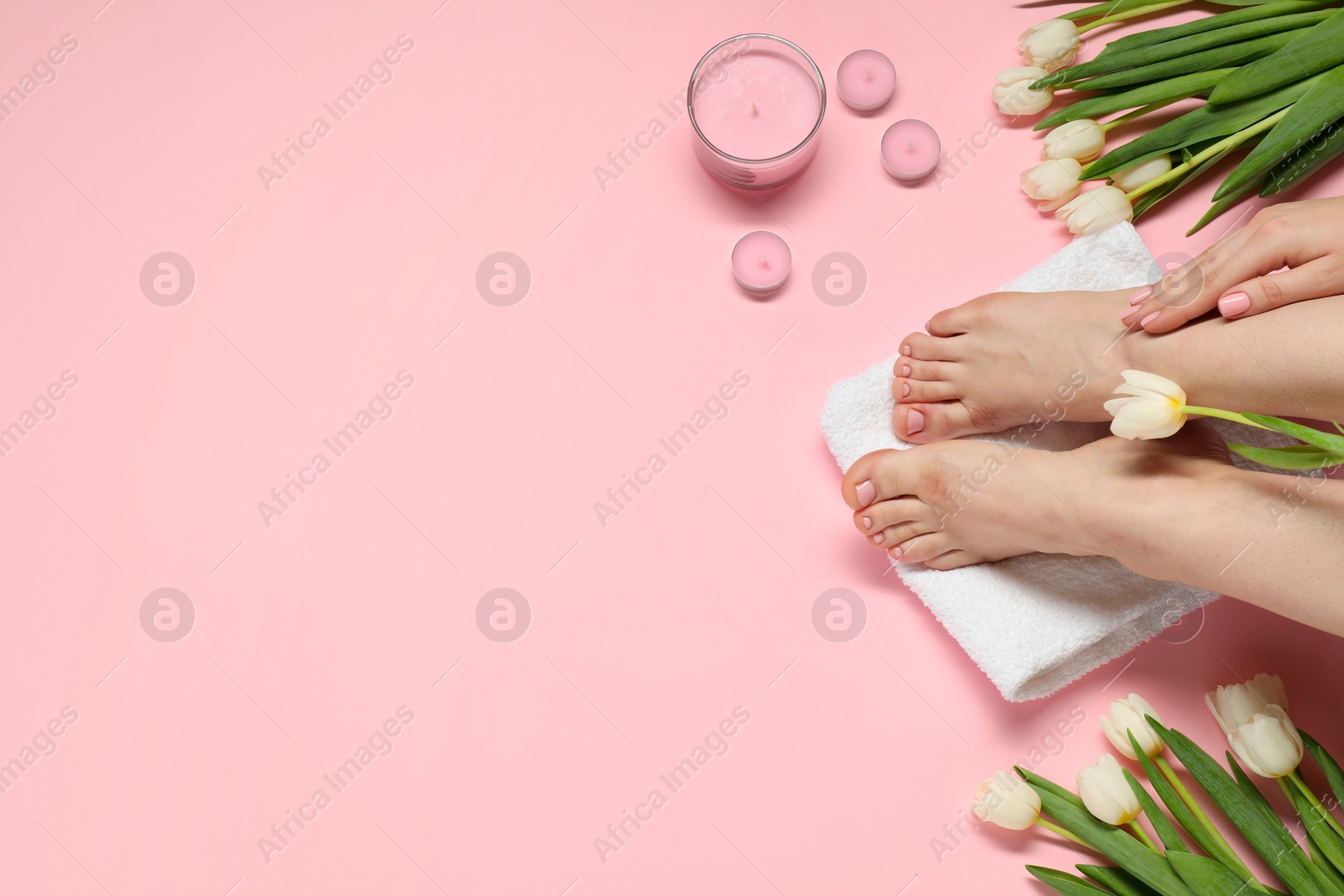 Photo of Closeup of woman with neat toenails after pedicure procedure on pink background, top view. Space for text