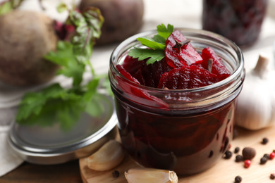 Delicious pickled beets and spices on wooden table, closeup