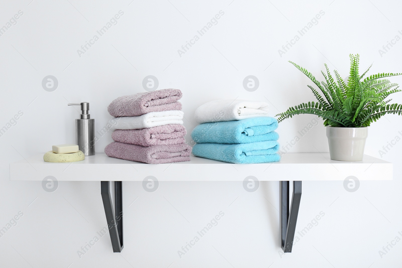 Photo of Clean towels on shelf in bathroom