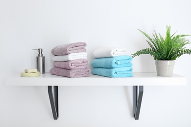 Clean towels on shelf in bathroom