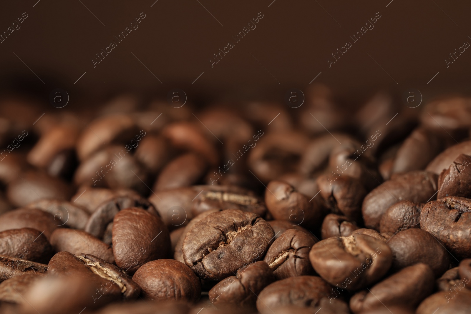 Photo of Heap of aromatic roasted coffee beans, closeup