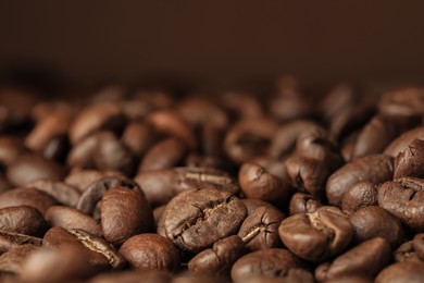 Photo of Heap of aromatic roasted coffee beans, closeup