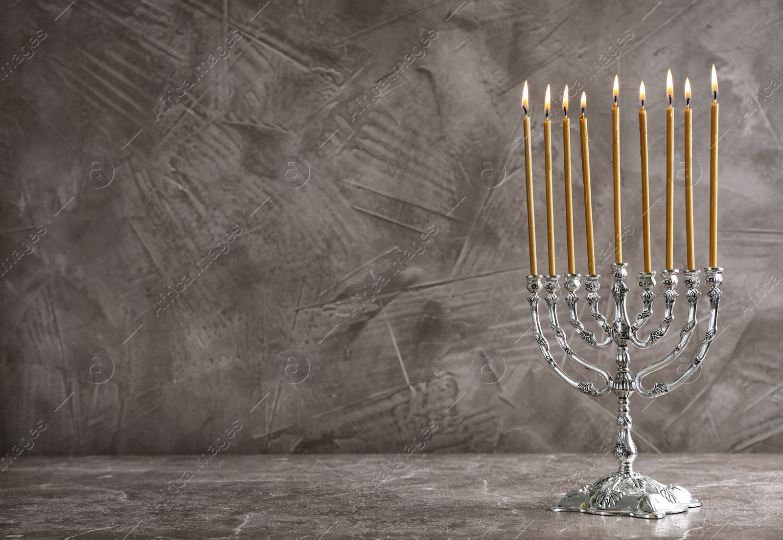 Photo of Hanukkah menorah on table against grey background