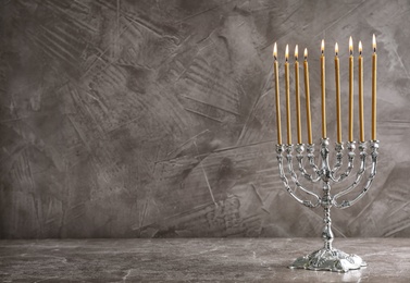 Hanukkah menorah on table against grey background