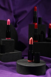 Stylish presentation of lipsticks on purple fabric