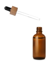 Photo of Dripping essential oil into glass bottle on white background